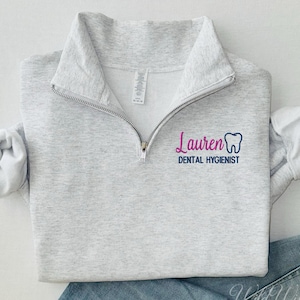 May include: A gray sweatshirt with a zipper and a navy blue and pink embroidered design that says "Lauren Dental Hygienist" with a tooth graphic.