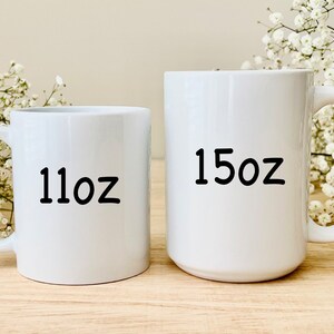 Pode incluir: Duas canecas de cer&acirc;mica branca com texto preto. A caneca menor diz "11oz" e a caneca maior diz "15oz".