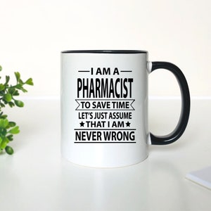 May include: White ceramic mug with a black rim and handle. The mug has a black graphic that reads "I am a Pharmacist. To save time let's just assume that I am never wrong."