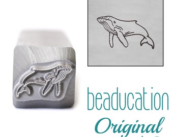 May include: A silver metal stamping tool featuring a raised humpback whale design on its square end. Next to the tool is a square graphic showing the whale design in black lines on a gray background, with the text beaducation Original below.