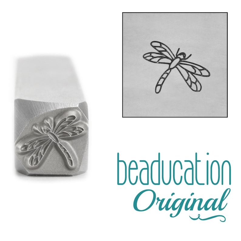 May include: A metal stamping tool with a square shaft featuring a dragonfly design engraved on the end. The tool is shown alongside a square inset displaying a black ink impression of the dragonfly motif and the teal text beaducation Original.