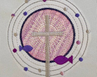 May include: Embroidered design featuring a cross with a pink and white center, surrounded by a circle of purple and gray dots and two purple fish.