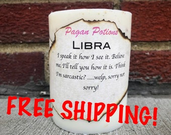 May include: White candle with a burnt label that reads "Pagan Potions Libra I speak it how I see it. Believe me, I'll tell you how it is. Think I'm sarcastic?....welp, sorry not sorry!" The candle is sitting on a brick surface with the words "FREE SHIPPING!" in red text.