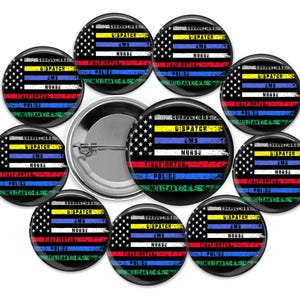 May include: A collection of round pinback buttons featuring a stylised American flag design. Each button displays horizontal stripes in yellow, blue, white, red, and green, with text labels including Corrections, Dispatch, EMS, Nurse, Firefighter, Police, and Military.