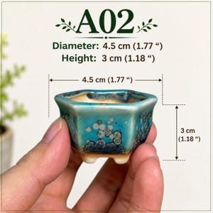 May include: A small hexagonal ceramic planter with a teal and blue crystalline glaze finish. The planter features three short feet and measures 1.77 inches in diameter and 1.18 inches in height, labeled as A02 with visible dimension markings.