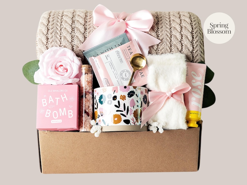 Peut inclure: Un panier cadeau rempli d'articles de bien-&ecirc;tre. Il comprend une bo&icirc;te de bombe de bain rose, une tasse &agrave; fleurs, du th&eacute;, une petite serviette nou&eacute;e avec un n&oelig;ud rose, une lotion &agrave; la rose et une rose rose. Le panier est doubl&eacute; d'une couverture en tricot de c&acirc;ble beige.
