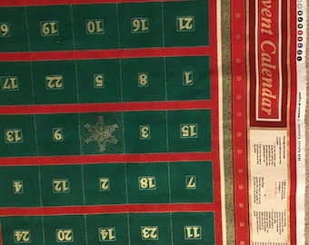 May include: A Christmas advent calendar made of fabric. The calendar has a red border with a green interior, featuring numbered pockets for each day of December leading up to Christmas. The words "Advent Calendar" are printed on the side.