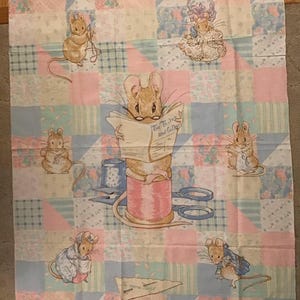 May include: A fabric panel featuring a patchwork design with illustrations of mice. The mice are depicted in various poses, some reading, sewing, and wearing clothing. The color palette includes pastel pink, blue, and beige.