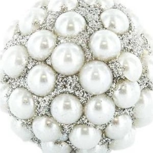 May include: A round, decorative ornament covered in faux pearls and silver glitter. The pearls are white and evenly spaced, creating a textured surface. The glitter fills the spaces between the pearls, adding sparkle.