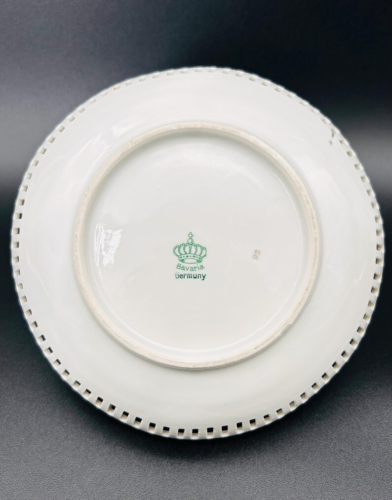 Peut inclure: Assiette en porcelaine blanche avec un bord festonn&eacute;. Le fond de l'assiette porte un logo de couronne verte avec le texte "Bavaria Germany".