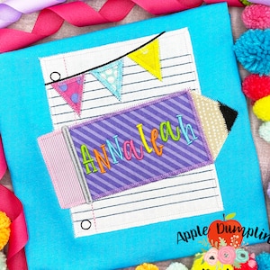 May include: A blue t-shirt with a white and black pencil design. The pencil is decorated with a purple and white striped pattern and the name "AnnaLeah" is written on it. There are colorful pennants above the pencil. The text "Apple Dumplin Design" is in the lower right corner of the image.
