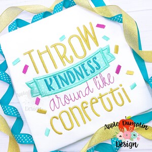 Könnte beinhalten: Ein weißes T-Shirt mit goldener Stickerei, auf dem "Throw Kindness Around Like Confetti" steht. Die Stickerei ist von buntem Konfetti umgeben.