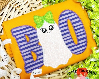 May include: A yellow fabric with a purple and white striped "BOO" with a white ghost with a green bow in the middle.