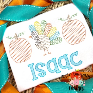 May include: A white onesie with a colorful turkey, two orange pumpkins, and the name "Isaac" embroidered in blue. The onesie is surrounded by orange and turquoise ribbon.