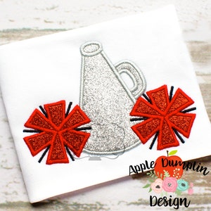 May include: A silver glitter megaphone with two red glitter pom-poms. The megaphone and pom-poms are embroidered on a white fabric.