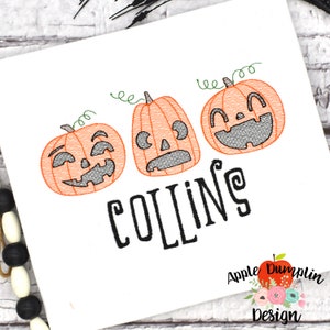 Puede incluir: Diseño bordado con tres calabazas naranja en forma de jack-o'-lantern con diferentes expresiones faciales. El texto "COLLINS" está bordado debajo de las calabazas.