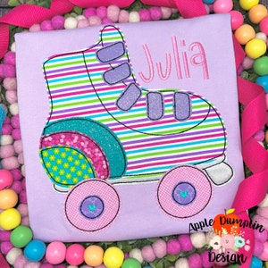 May include: A purple shirt with a colorful roller skate design and the name "Julia" embroidered on the front.
