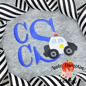 May include: Embroidered design on a gray shirt featuring the letters "CC" in blue with a white police car in the center. The police car has a blue light on top, a yellow star on the side, and black wheels. The text "Apple Dumplin Design" is visible below the car.