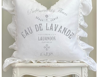 May include: White linen pillow with a gray embroidered design that reads "Parfumerie des Fleurs Eau de Lavande Preparee par Lauandos Parfumeur Paris".