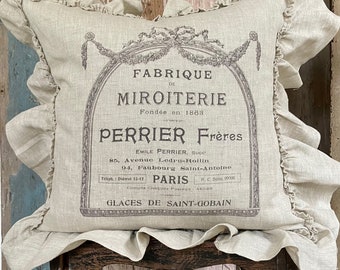 May include: A beige linen pillow with a ruffled edge features a vintage French print advertising a mirror shop called "Perrier Frères" in Paris. The print includes the address, phone number, and postal account information.