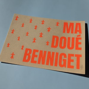 May include: A brown paper print with orange text that reads "MA DOUE BENNIGET". The background is decorated with a repeating pattern of small orange stars.