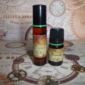 May include: Two brown glass bottles with green labels that read "Sinus Oil". The bottles are sitting on a table with a patterned background.