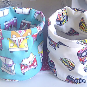 May include: Two fabric storage baskets with a colourful design of vintage vans. One basket is turquoise with white vans and the other is white with colourful vans.
