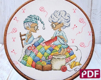 May include: Cross stitch pattern featuring two people sitting on a quilt, sewing. The pattern is in a round wooden frame and includes 39 DMC colors. The pattern is 5.93 inches by 5.79 inches and has 83 stitches by 81 stitches.