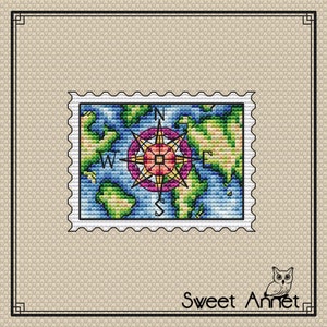 May include: A colorful compass rose with a world map background, surrounded by a white border, resembling a postage stamp. The compass rose is in shades of pink, yellow, and green, with the letters N, S, E, and W for the cardinal directions.