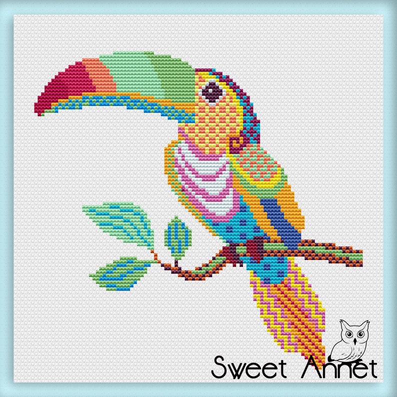 May include: A cross-stitch design depicting a toucan on a branch. The bird has a large, multi-coloured beak and bright feathers in red, green, yellow, and blue. The text "Sweet Annet" is at the bottom of the image.