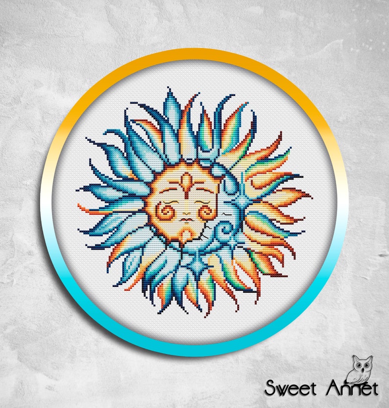 May include: A cross-stitch pattern featuring a stylised sun and moon design. The sun has a face and is surrounded by blue, orange and yellow rays. The moon is crescent-shaped and is behind the sun.