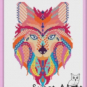 May include: A cross-stitch design of a wolf's head, with a vibrant palette of pink, orange, blue, and yellow. The geometric pattern is detailed. The text "Sweet Annet" is at the bottom, with an owl illustration. The background is white.