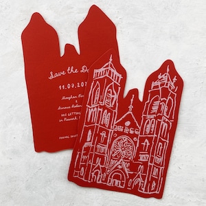 May include: Red wedding invitations with a church illustration and the text "Save the Date" and event details. The invitations are uniquely shaped with a decorative top.