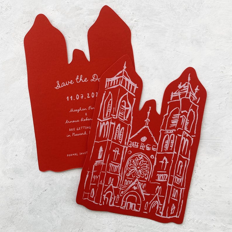 May include: Red wedding invitations with a church illustration and the text "Save the Date" and event details. The invitations are uniquely shaped with a decorative top.