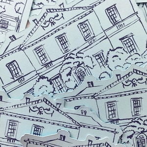 May include: A collection of light blue die-cut stickers featuring a detailed black and white illustration of a stately building with multiple windows, a decorative roof, and surrounding trees. The stickers are scattered across the image.