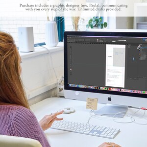 May include: A woman working on a computer, designing a menu. The computer screen shows a menu design with the text "MENU" at the top. The woman is wearing a purple sweater and is using a keyboard.