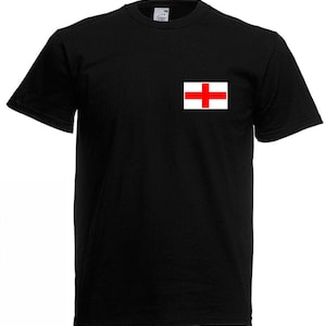 May include: Black crew neck t-shirt with a small white and red flag emblem on the chest. The flag features a red cross on a white background. The shirt is made of a soft material and has short sleeves.
