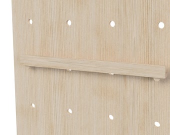 May include: A close-up of a light wood pegboard with a wooden shelf attached. The pegboard has evenly spaced holes for hanging items.