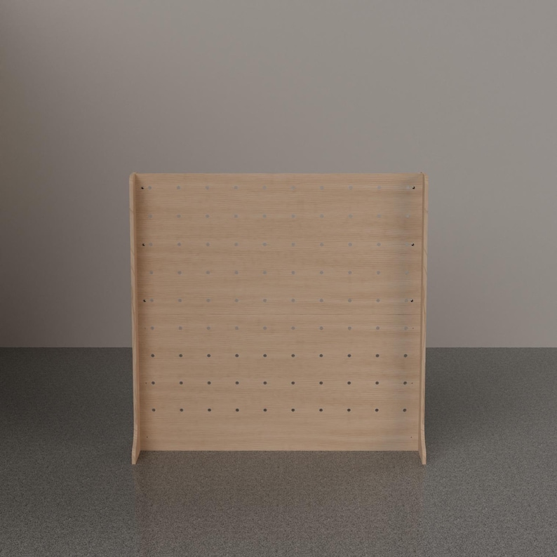 May include: A light-colored wooden pegboard display stand featuring a rectangular front panel with a grid of evenly spaced circular holes. The structure includes two side supports that extend slightly forward at the base for stability.