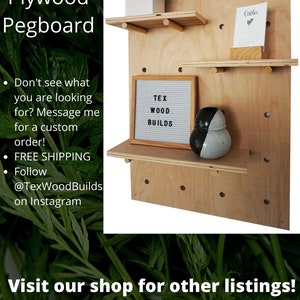 Puede incluir: Un tablero perforado de madera contrachapada de color claro con tres estantes horizontales sujetos por clavijas de madera. Los estantes sostienen una maceta blanca, un calendario peque&ntilde;o, un tablero de fieltro gris con el texto TEX WOOD BUILDS y un jarr&oacute;n blanco y negro.