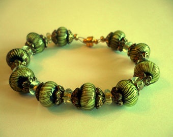 Black, gold and a hint of green.  Small black stripes on these glass beads.