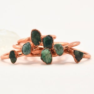 May include: Set of five copper rings with green gemstone accents. Each ring features a different shaped stone.