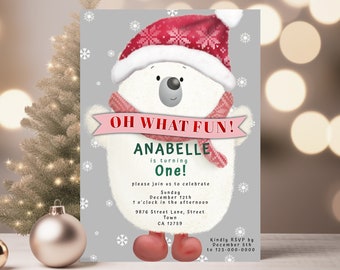 May include: A festive invitation card with a cartoon polar bear wearing a red and white knit hat and scarf. The text on the card reads "OH WHAT FUN! ANABELLE is turning One!" and includes details for a birthday party.