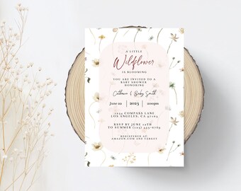 May include: A white baby shower invitation with a floral design. The invitation reads "A Little Wildflower is Blooming" and includes the date, time, and location of the shower. It also includes the names "Catherine & Baby Smith" and the RSVP information.