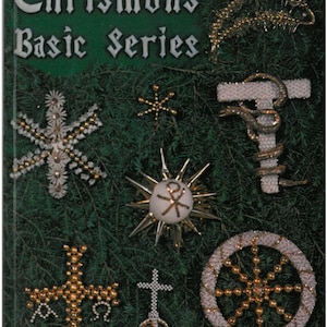 May include: A collection of handmade Chrismons ornaments, including crosses, stars, and a wheel, displayed on a bed of evergreen branches. The ornaments are crafted with gold and silver beads, and the text "Chrismons Basic Series" is visible.