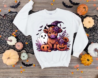 May include: White sweatshirt with a Halloween-themed graphic. The design features a brown cow wearing a witch hat, a ghost, and jack-o'-lanterns. The sweatshirt is surrounded by pumpkins, bats, and spiderwebs, creating a festive autumn look.