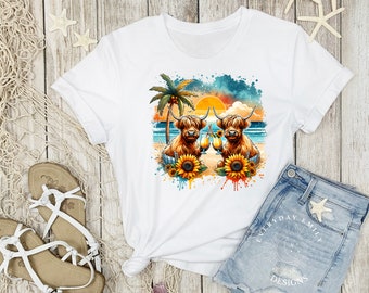 May include: White t-shirt featuring a watercolor design of two Highland cows on a beach with cocktails, sunflowers, and a sunset. The design includes a palm tree and ocean waves. The shirt is paired with denim shorts and sandals.