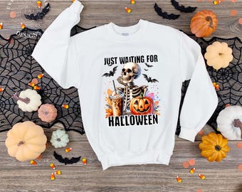 May include: White sweatshirt with a Halloween-themed graphic. The design features a skeleton holding a drink and a pumpkin, with the text "Just Waiting For Halloween". Bats and fall foliage complete the design.