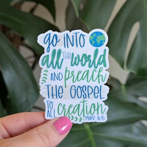 May include: A white sticker with the text "Go into all the world and preach the gospel to all creation" in blue and green. A small globe graphic is at the top. The text "Mark 16:15" is at the bottom.