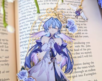 May include: A detailed bookmark featuring a celestial anime-style character with blue hair and wings, adorned with purple roses. The bookmark has a gold border and is set against the backdrop of an open book.